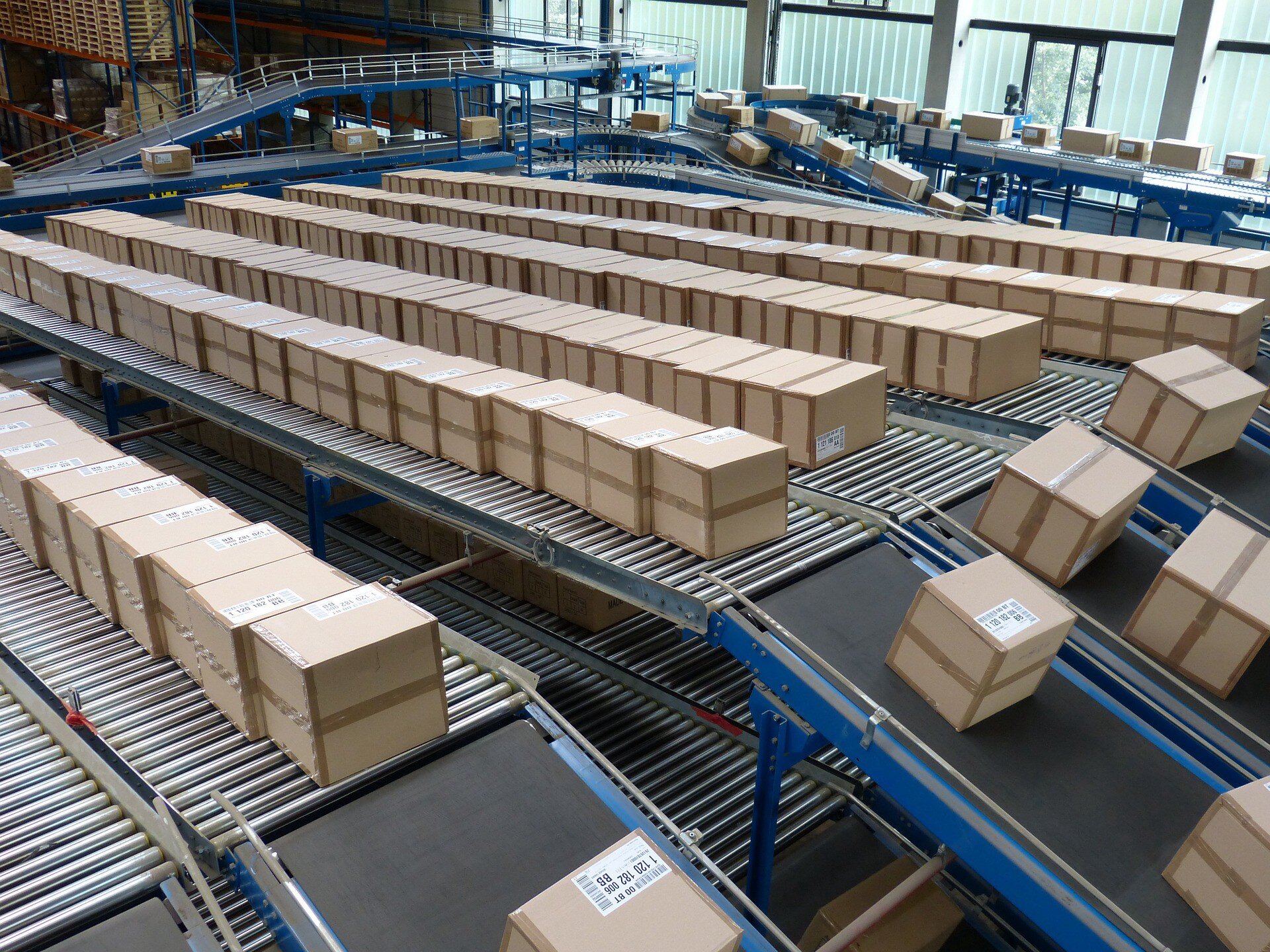 Rows of packaged boxes moving along warehouse conveyor belts