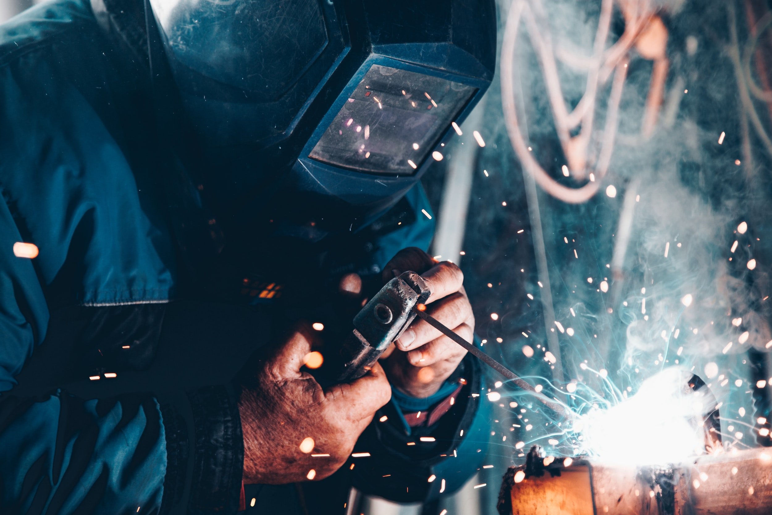 A welder at work, sparks flying from the joint